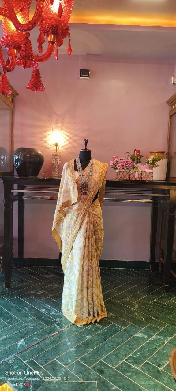 Mustard yellow chiffon cotton saree with digital floral prints and chikankari borders.