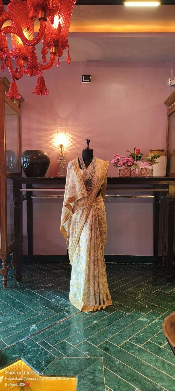 Mustard yellow chiffon cotton saree with digital floral prints and chikankari borders.